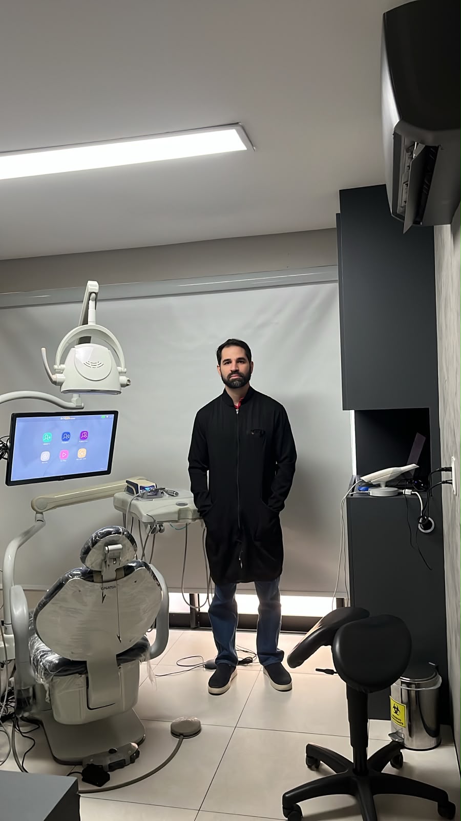 Dr. Rubens Moises Said Filho no consultório da Odonto Said ao lado da cadeira odontológica
